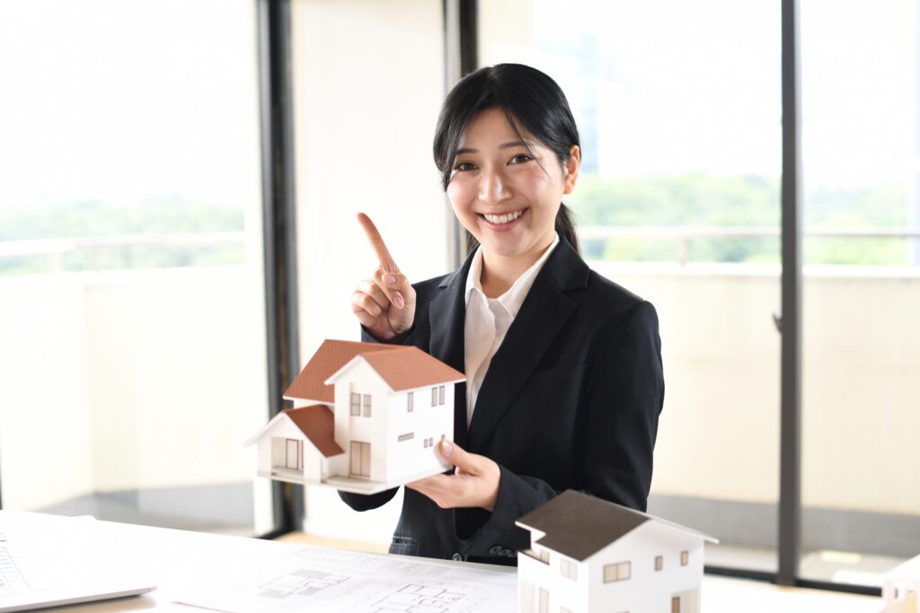 家の模型を手に持つ女性社員